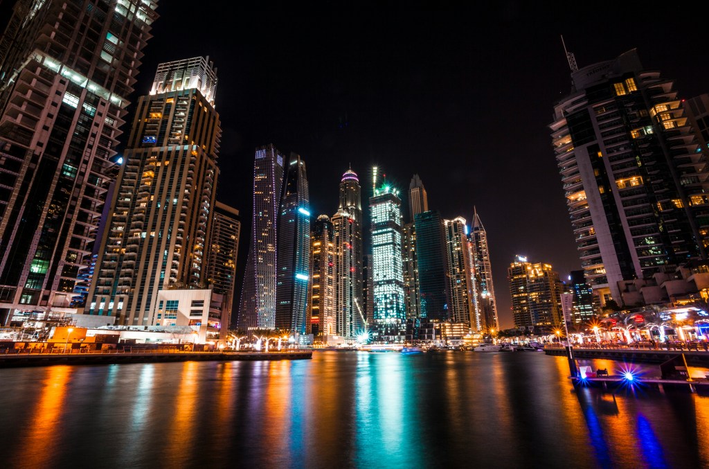 Dubai Marina skyscrapers lit up at night and reflected in the water