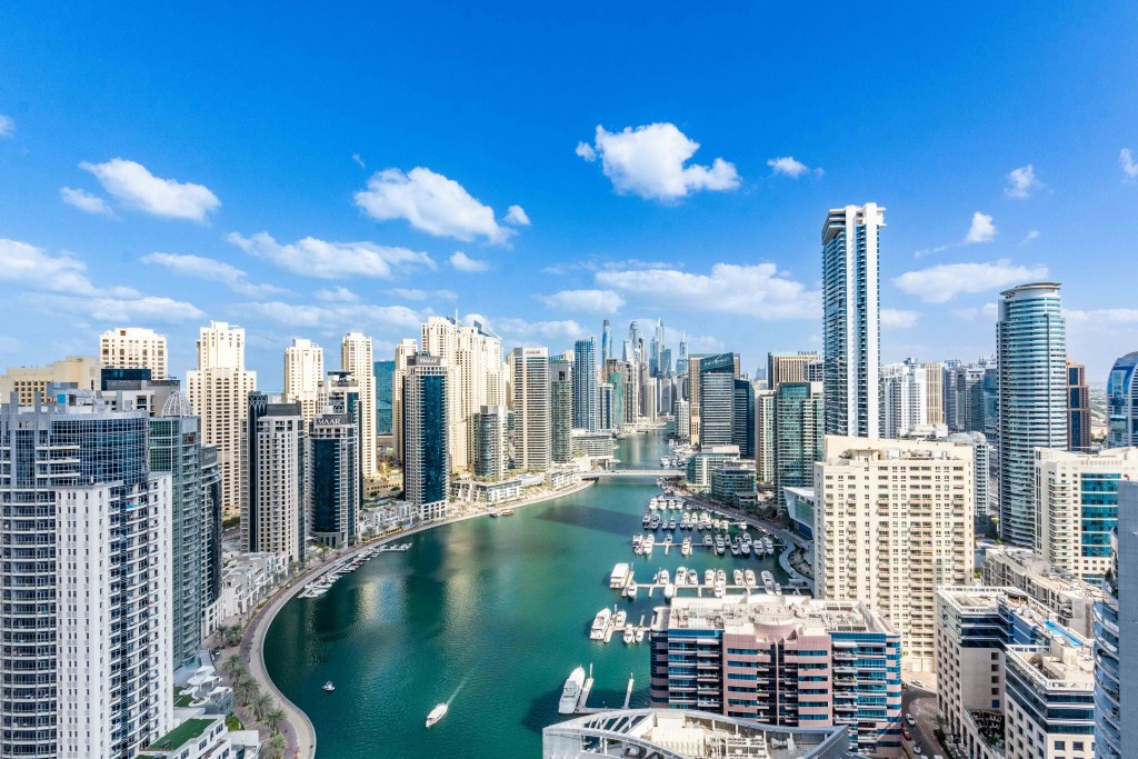 Aerial view of Dubai Marina with yachts and high-rise apartment towers