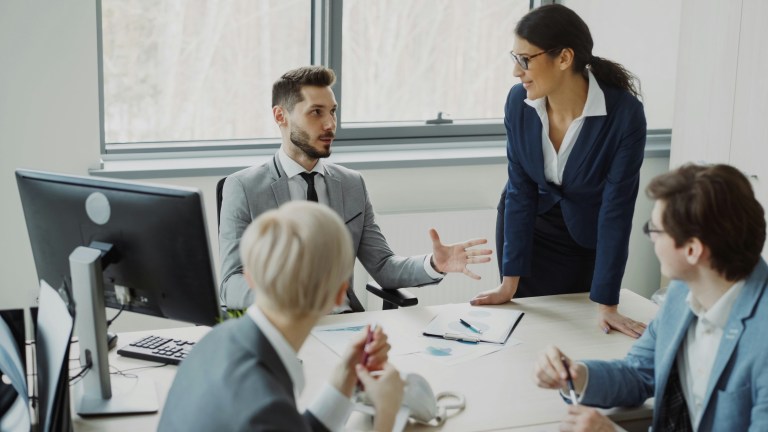 Businesswoman standing to lead a team meeting in a modern office